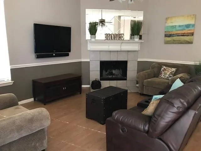 a living room with furniture a flat screen tv and a fireplace
