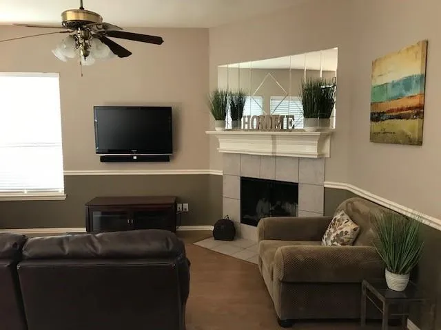 a living room with furniture a flat screen tv and a fireplace