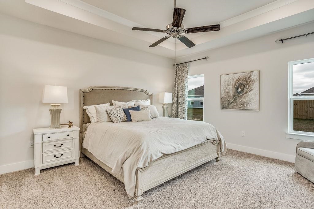 7637 Saddlebrook Avenue Pace, FL 32571 - Photo 20 of 28 a spacious bedroom with a bed a dresser and painting on the wall