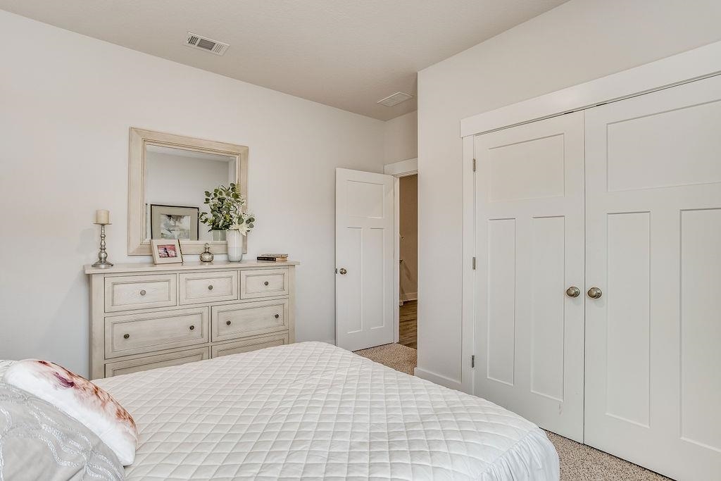 7637 Saddlebrook Avenue Pace, FL 32571 - Photo 5 of 28 a bedroom with a bed and a mirror on dresser