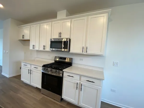 a kitchen with stainless steel appliances white cabinets and a stove top oven