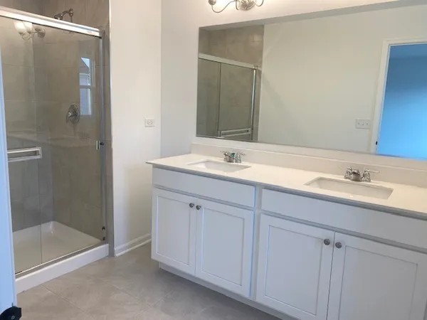 a bathroom with a shower sink and mirror