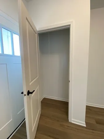 an empty room with wooden floor and entrance