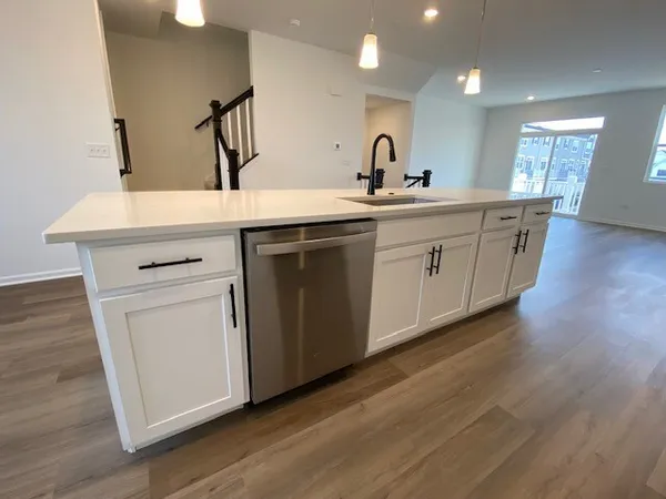 a kitchen with a sink cabinets and wooden floor
