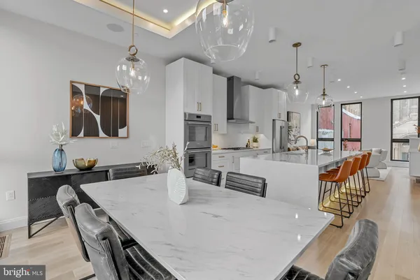 a kitchen with kitchen island a stove a table a sink and a refrigerator