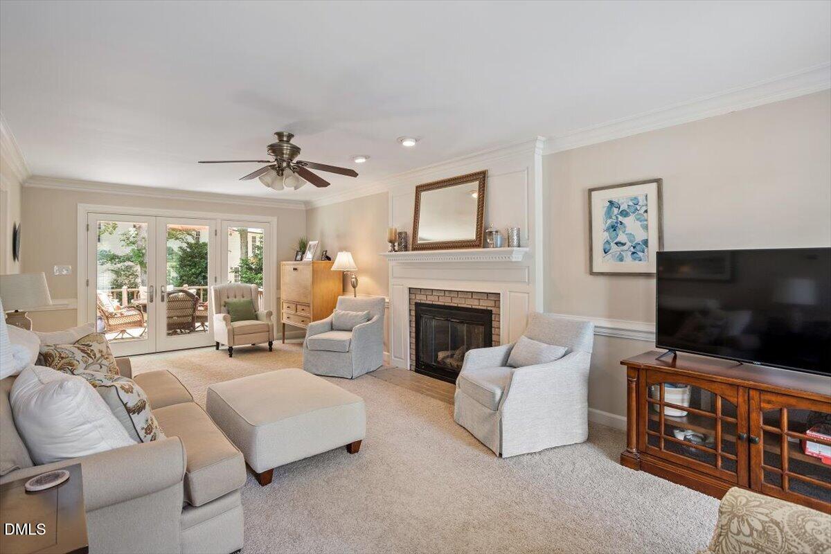 1808 Thorpshire Drive Raleigh, NC 27615 - Photo 3 of 17 a living room with furniture a flat screen tv and a fireplace