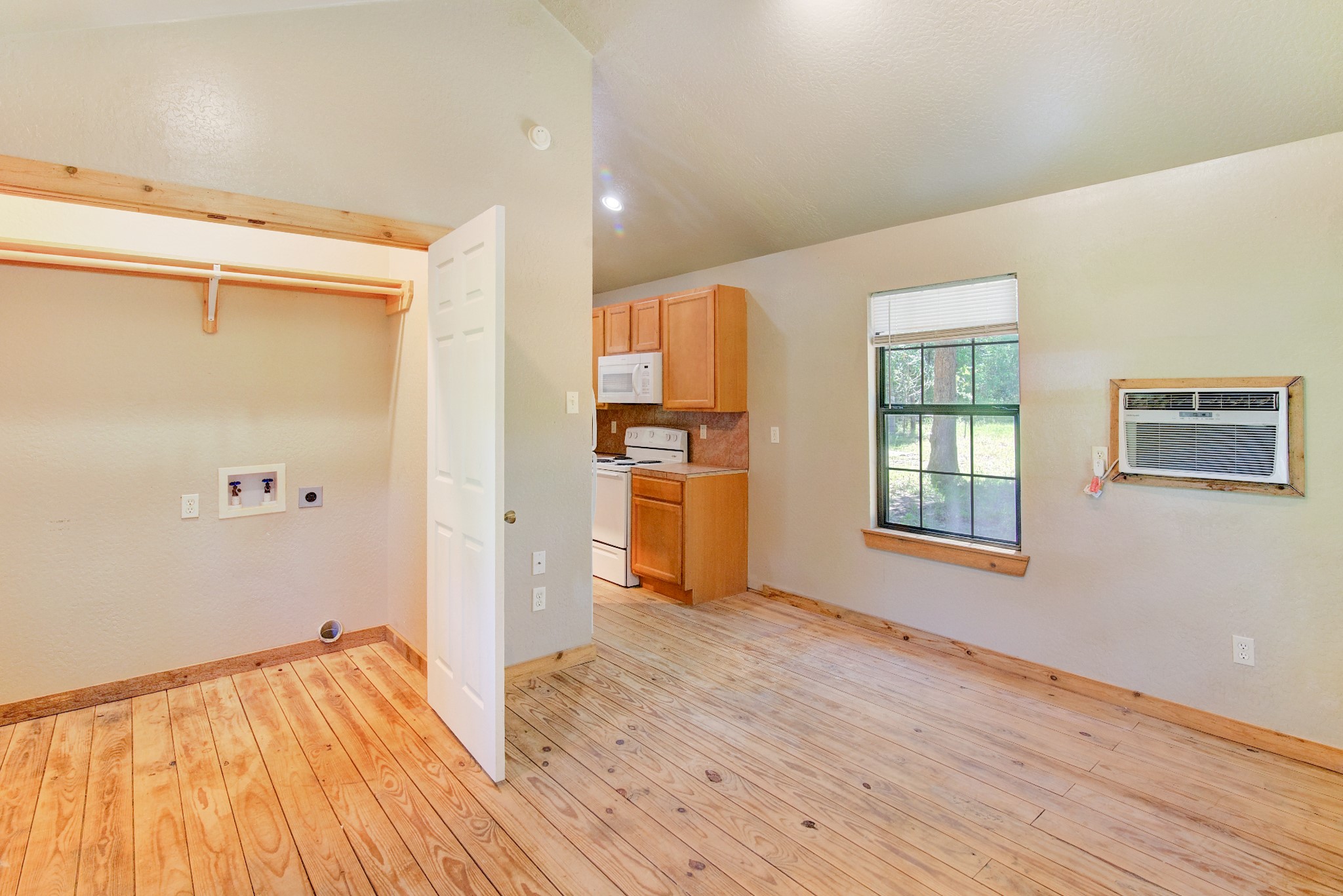 10521 Tanyard Road, Unit SM Willis, TX 77378 - Photo 2 of 11 This space is the living/dining/bedroom. It's cozy and is really all that you need. The W/D connections are in this closet. The tiny house has a window unit and a ceiling fan, and windows are covered with blinds.
