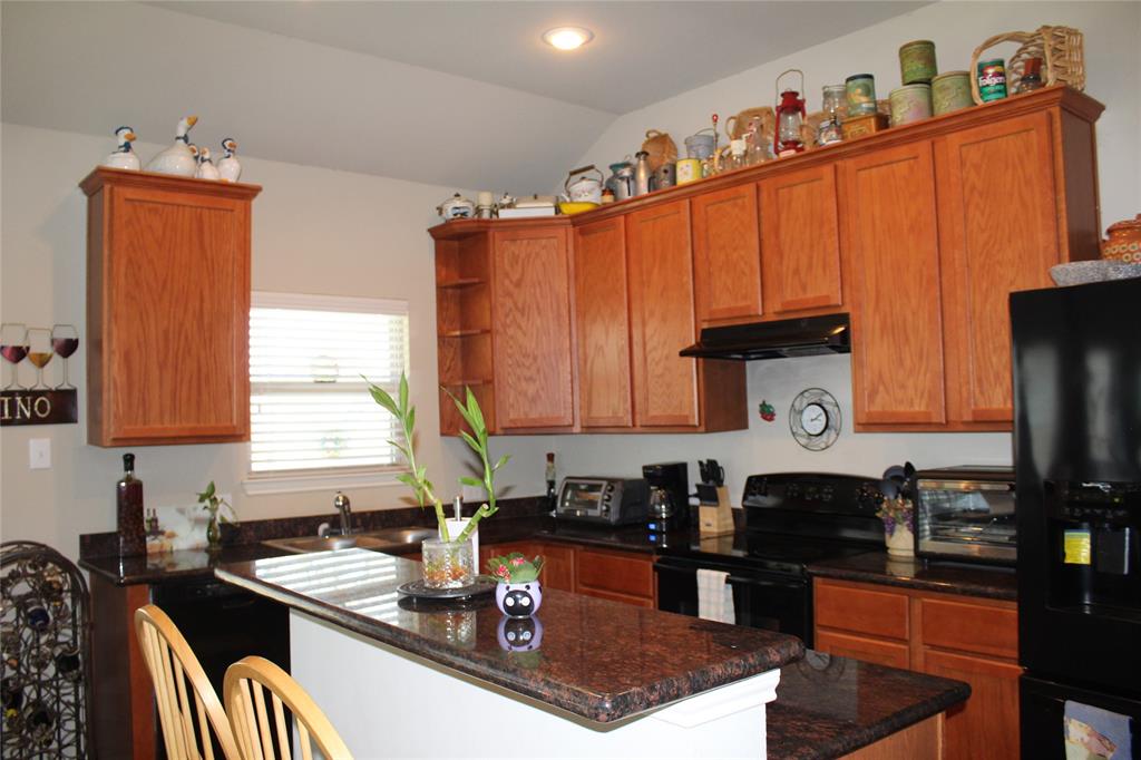 10717 Fallbrook Road Waco, TX 76708 - Photo 11 of 33 a kitchen with granite countertop a sink stove and cabinets