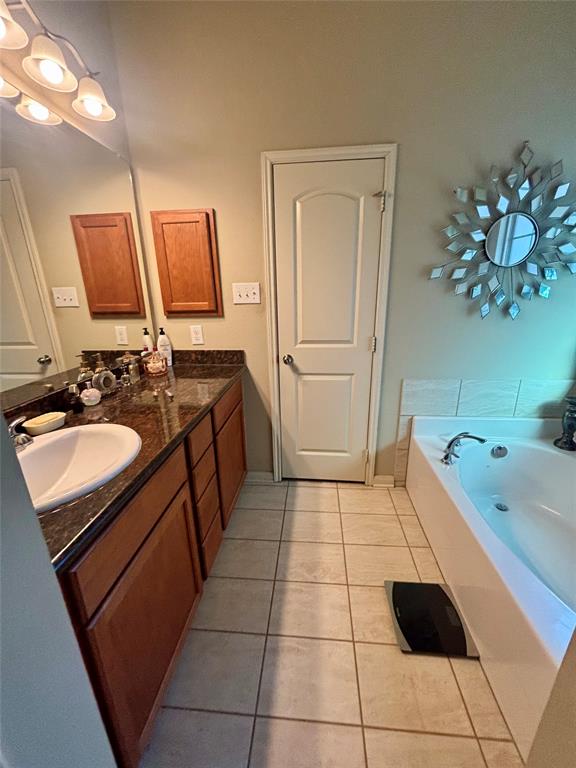 10717 Fallbrook Road Waco, TX 76708 - Photo 22 of 33 a bathroom with a sink a vanity a mirror and a bathtub