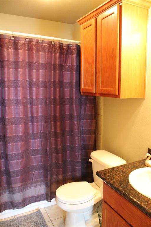 10717 Fallbrook Road Waco, TX 76708 - Photo 26 of 33 a bathroom with a granite countertop toilet and a sink