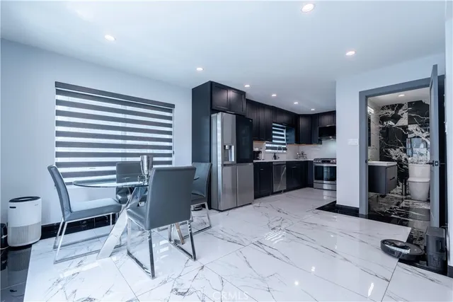 a kitchen with stainless steel appliances kitchen island granite countertop a refrigerator and a sink