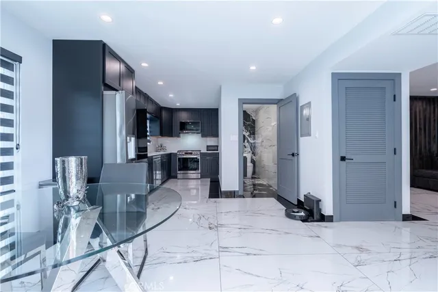 a kitchen with stainless steel appliances kitchen island granite countertop a refrigerator a sink a stove and oven