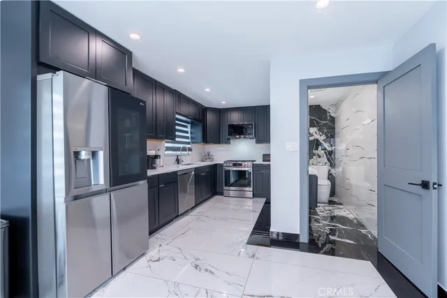 a kitchen with stainless steel appliances granite countertop a sink stove and refrigerator