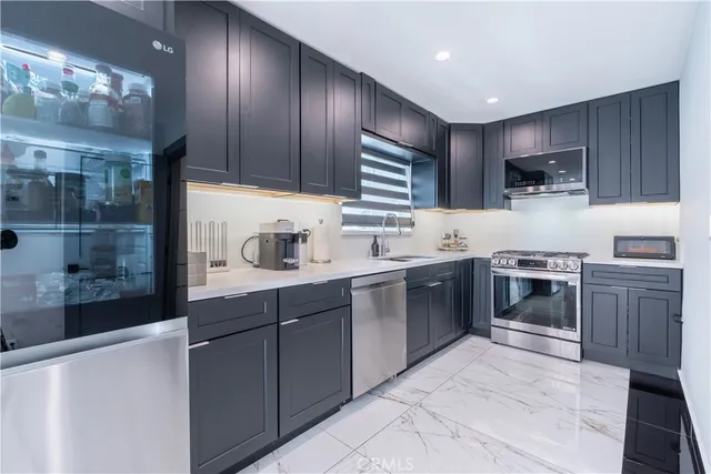 a kitchen with stainless steel appliances granite countertop a refrigerator and a stove