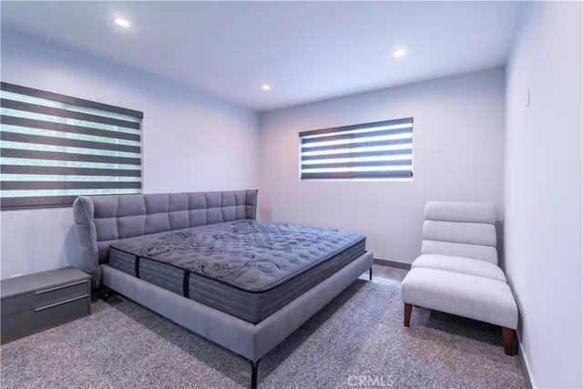 a spacious bedroom with a bed and chair