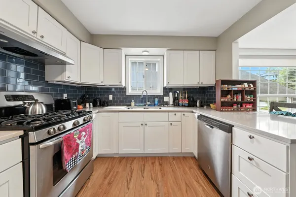 a kitchen with stainless steel appliances granite countertop a stove a sink and a microwave
