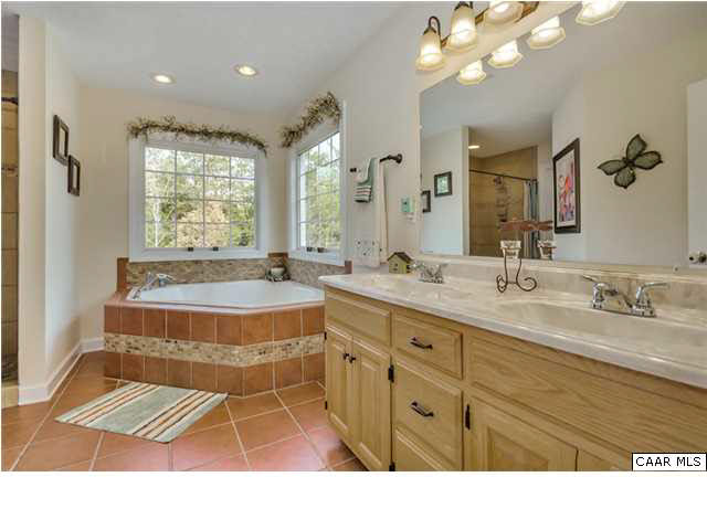686 Valley View Road Ruckersville, VA 22968 - Photo 17 of 33 a bathroom with a sink double vanity granite tub and a large mirror