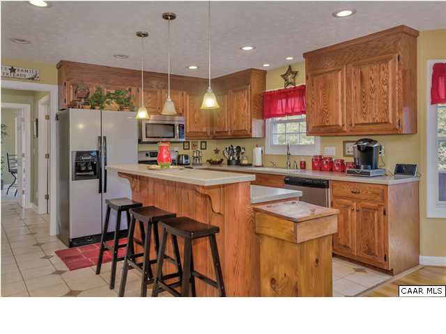 686 Valley View Road Ruckersville, VA 22968 - Photo 26 of 33 a kitchen with stainless steel appliances kitchen island granite countertop a table chairs and a refrigerator