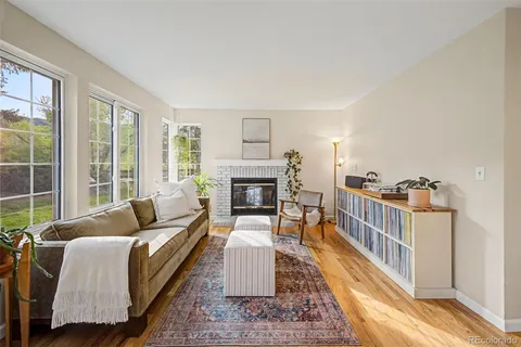 a living room with furniture a fireplace and a floor to ceiling window