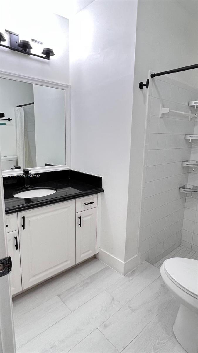 10669 Boca Entrada Boulevard Boca Raton, FL 33428 - Photo 12 of 19 a bathroom with a granite countertop sink mirror vanity and toilet