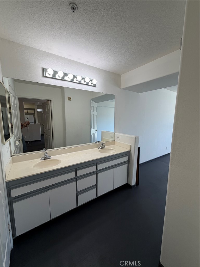 15455 Sherman Way, Unit 11 Van Nuys, CA 91406 - Photo 3 of 11 a bathroom with a double vanity sink and a mirror