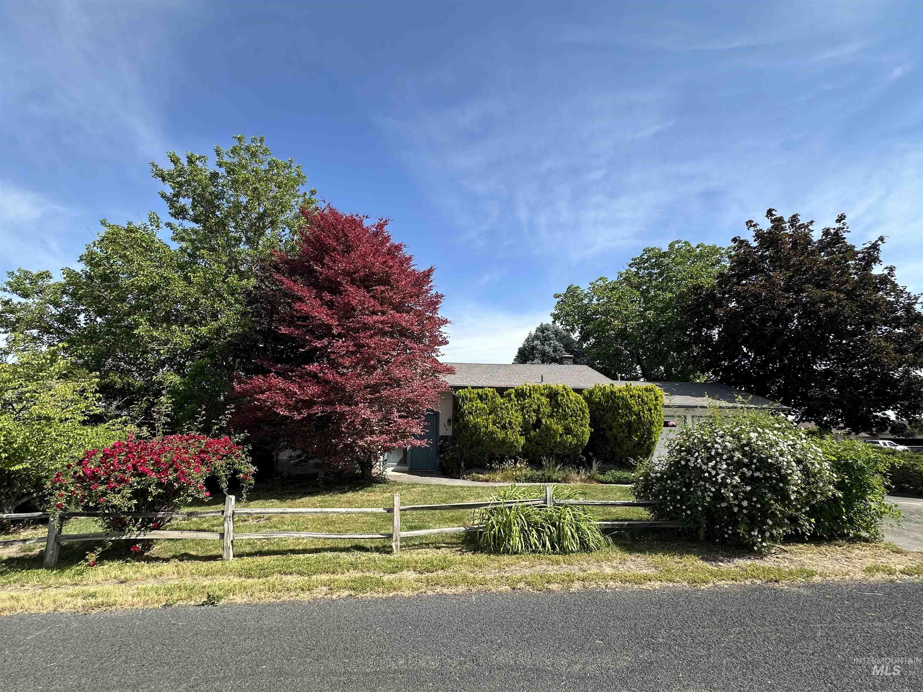 1620 6th Avenue Clarkston, WA 99403 - Photo 1 of 19 Residential property with a split-rail fence, mature landscaping, and a manicured lawn