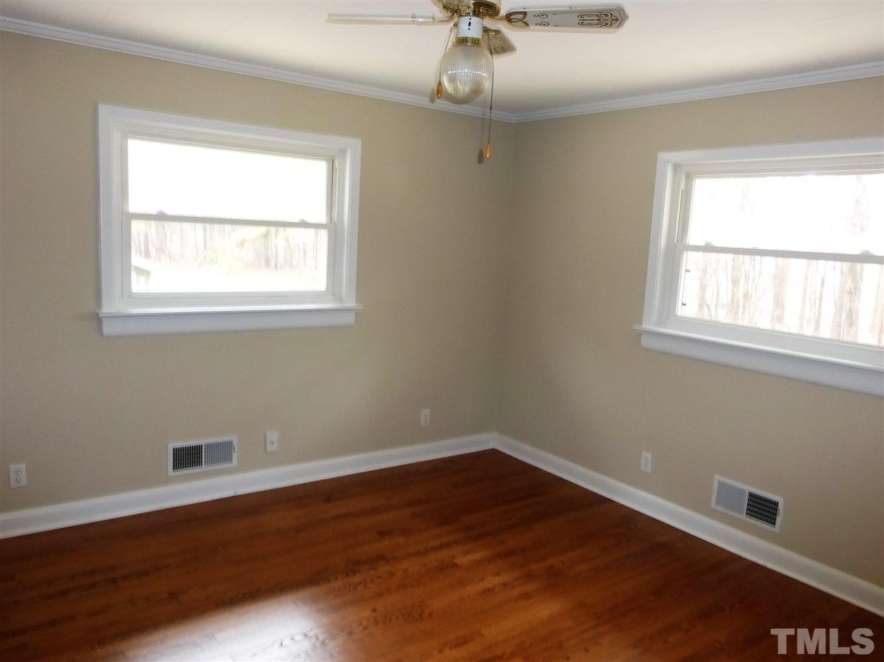 2314 Carpenter Pond Road Raleigh, NC 27613 - Photo 12 of 12 a view of an empty room with wooden floor and a window