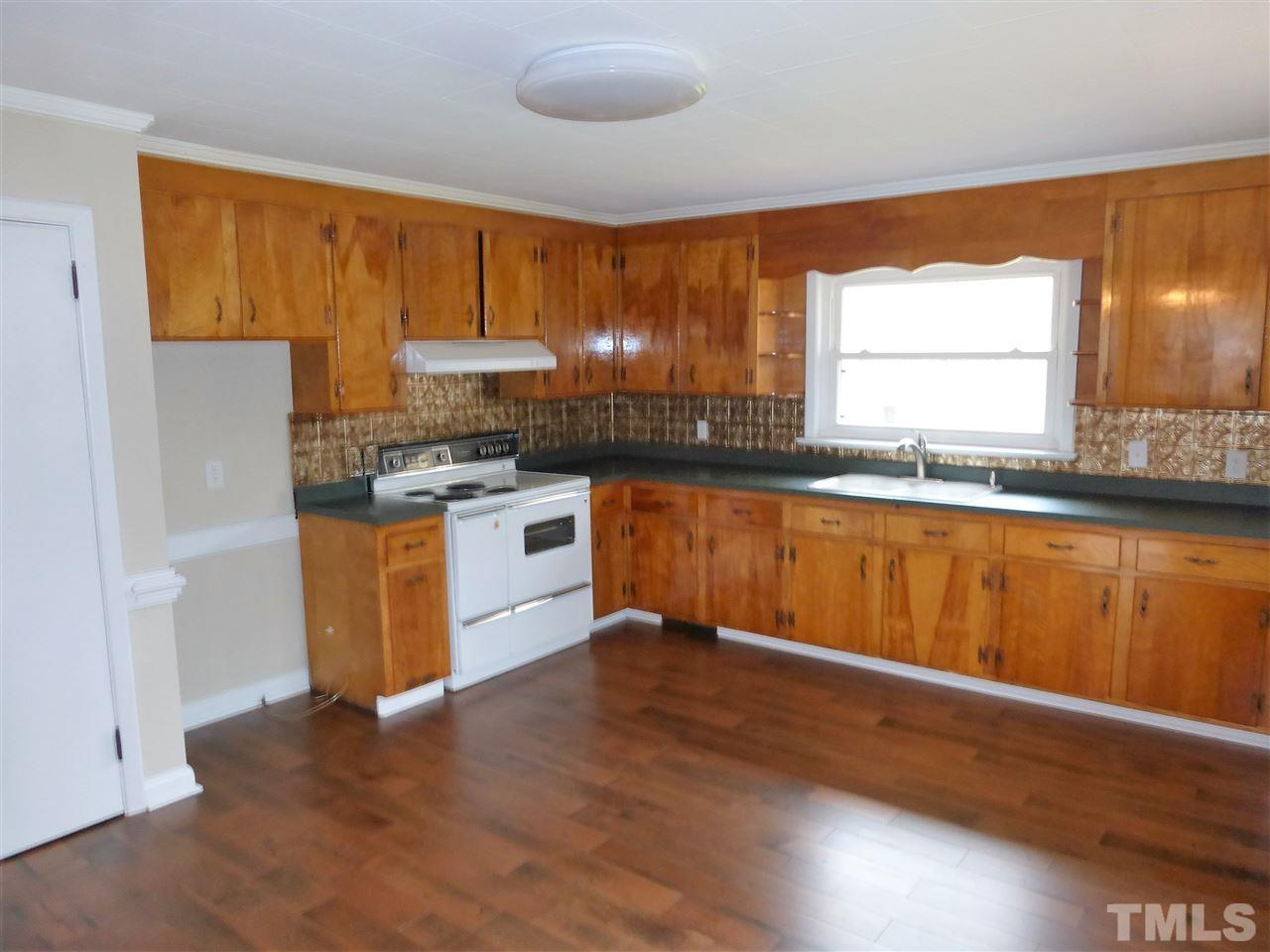 2314 Carpenter Pond Road Raleigh, NC 27613 - Photo 7 of 12 a kitchen with granite countertop wooden floors and white stainless steel appliances