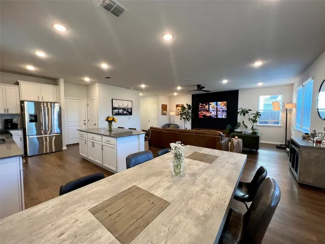 a living room with furniture and a glass table with wooden floor