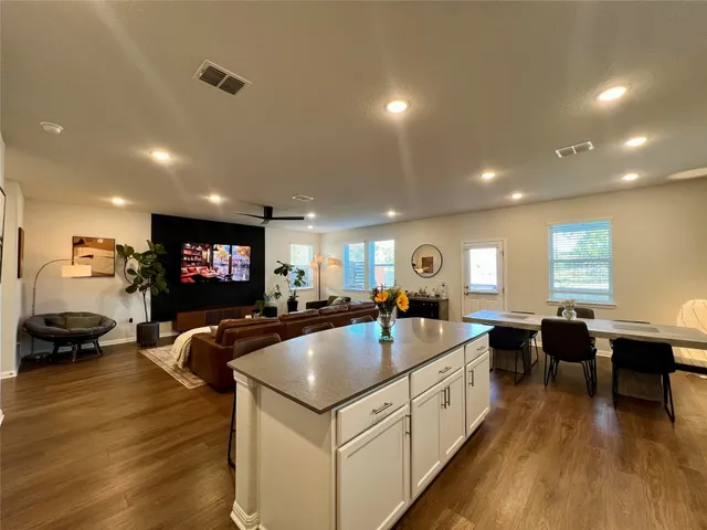 a view of a living room and dining room with furniture wooden floor and chandelier