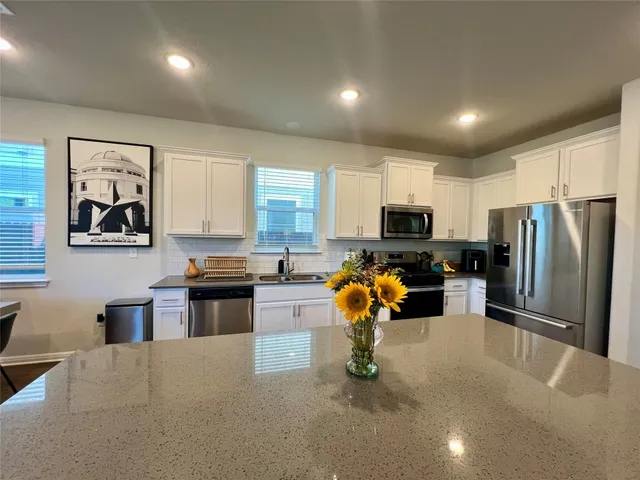 a kitchen with granite countertop stainless steel appliances and a refrigerator