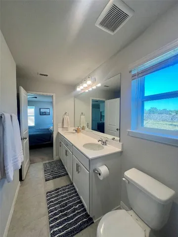 a bathroom with a double vanity sink toilet and a tub