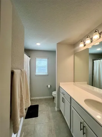 a spacious bathroom with a double vanity sink and a mirror
