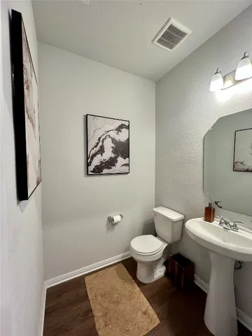 a bathroom with a toilet a sink and mirror