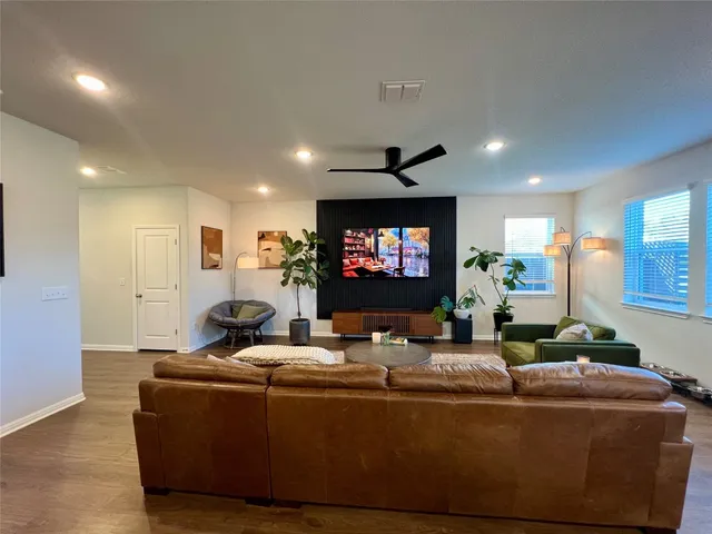 a living room with furniture a flat screen tv and a fireplace