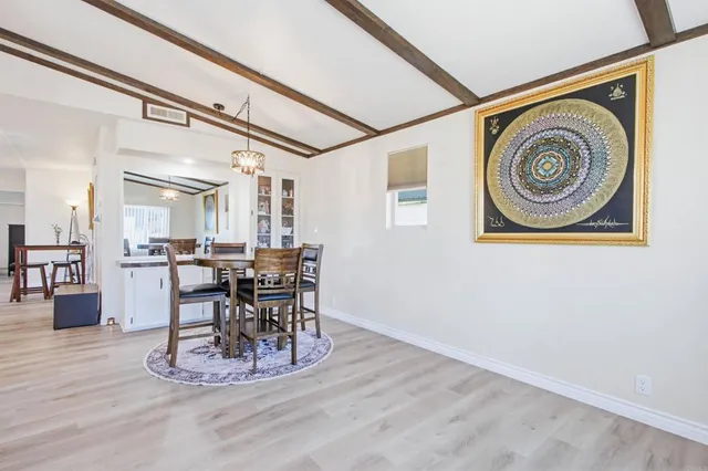 a view of a dining room with furniture a chandelier and wooden floor