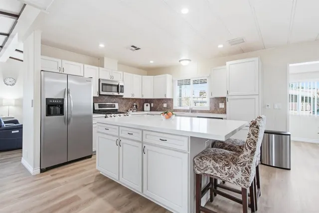 a large white kitchen with cabinets