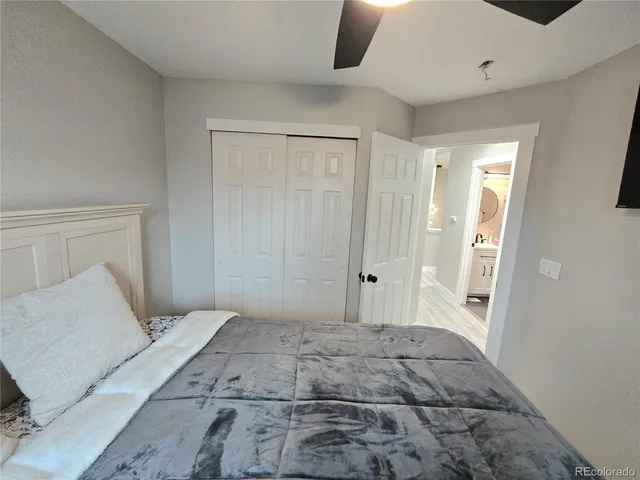a bedroom with a bed and a large mirror with a hardwood