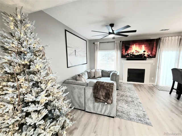 a living room with furniture a flat screen tv and a fireplace