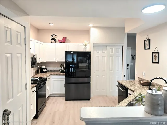 a kitchen with stainless steel appliances kitchen island granite countertop a refrigerator stove and sink