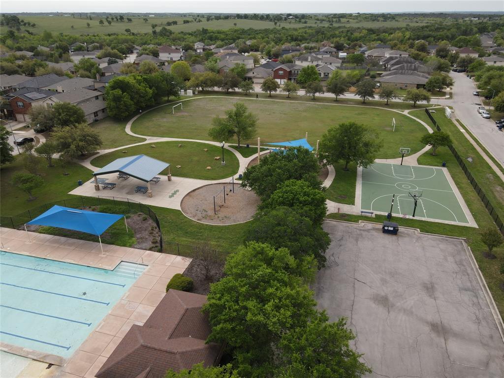 18021 Prairie Verbena Lane Elgin, TX 78621 - Photo 32 of 33 An aerial perspective reveals the vibrant community park, complete with a sparkling pool and recreational courts.