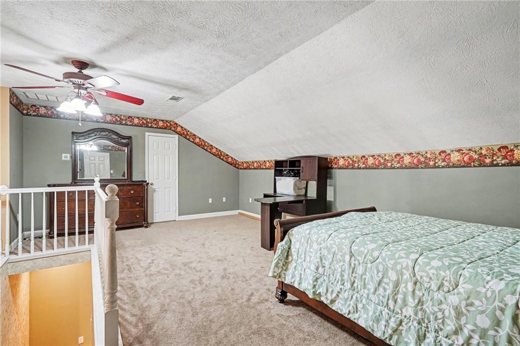 526 Antioch Church Road Talking Rock, GA 30175 - Photo 21 of 38 a bedroom with a bed and a chandelier