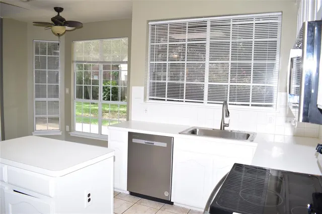 a kitchen with a stove a sink and a granite counter tops with a large window
