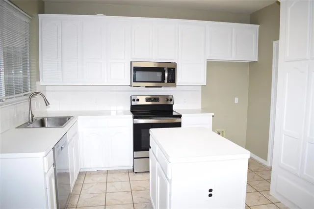 a kitchen with a sink and a stove top oven with wooden floor