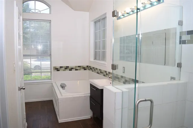 a bathroom with a bathtub a sink and a window