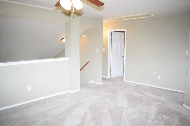 a view of an empty room with a chandelier fan
