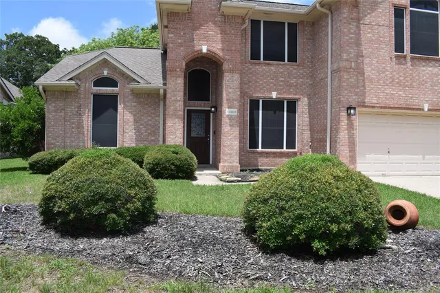 a view of a house with brick walls and a garden