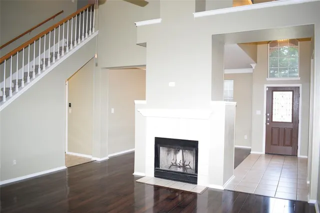 a living room with wooden floor and a fireplace