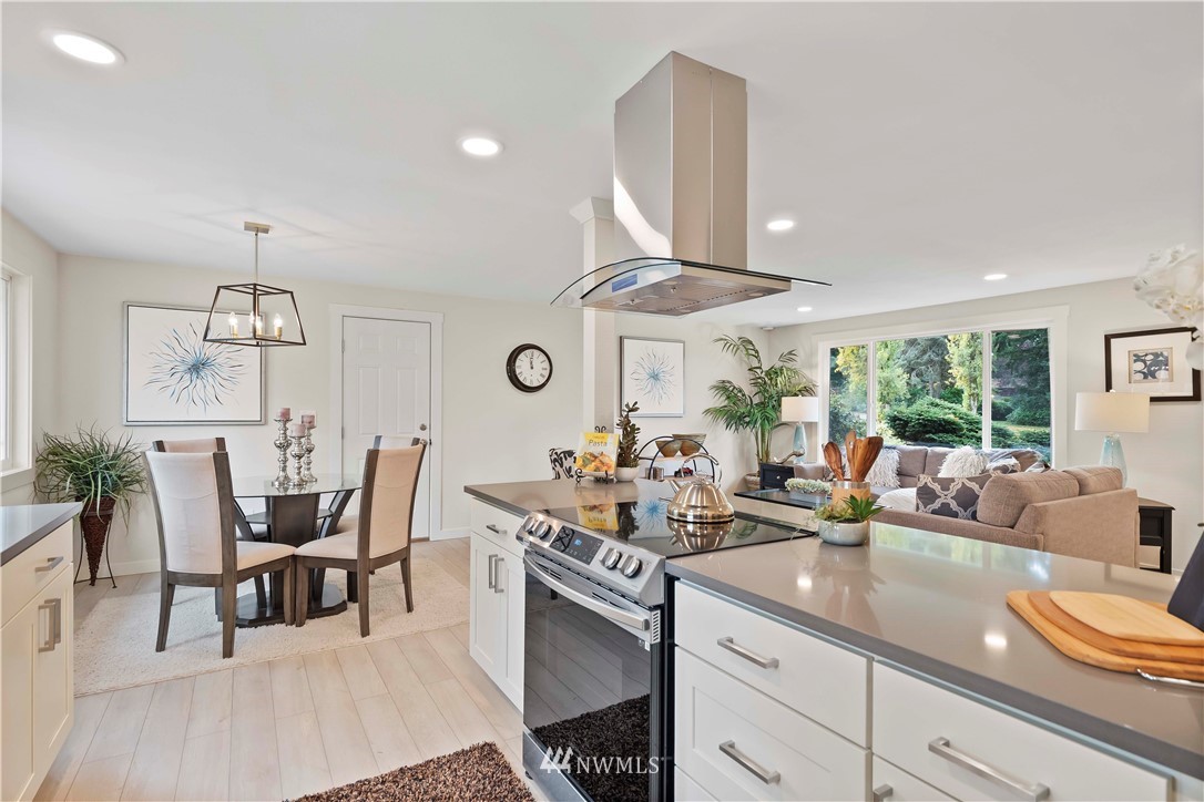 5723 Highland Road Everett, WA 98203 - Photo 9 of 21 a kitchen with stainless steel appliances a dining table chairs and white cabinets