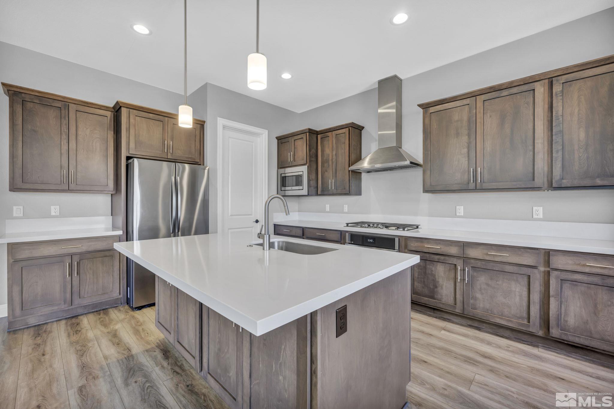 3108 Cambria Loop Carson City, NV 89703 - Photo 9 of 39 a kitchen with stainless steel appliances a sink a stove a refrigerator cabinets and wooden floor